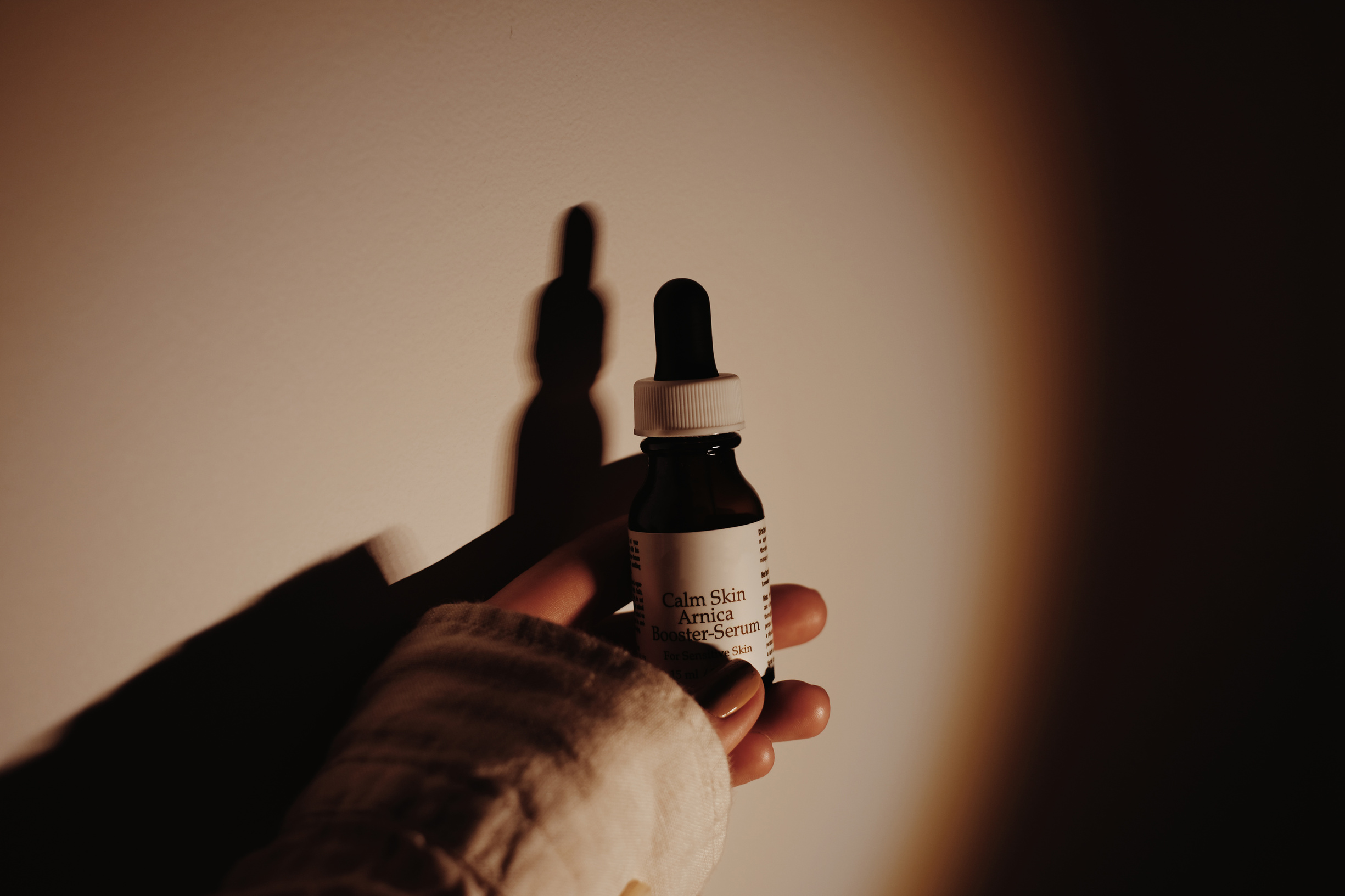 Woman holding skincare product in dropper bottle
